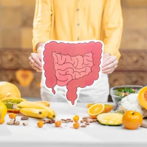 an image of a person holding a picture of a healthy gut over a table full of fruits and nuts