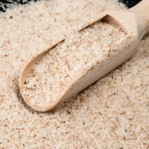 a wooden scoop full of psyllium husk on a sack of psyllium husk