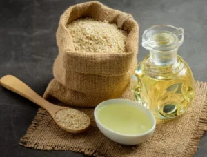 A sack and spoonful of Psyllium Husk and a bottle of oil on a weaved cloth
