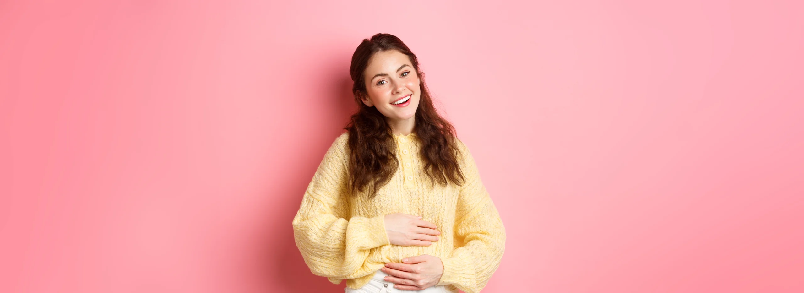 young smiling woman touching her stomach with relieved happy face feeling good after eating