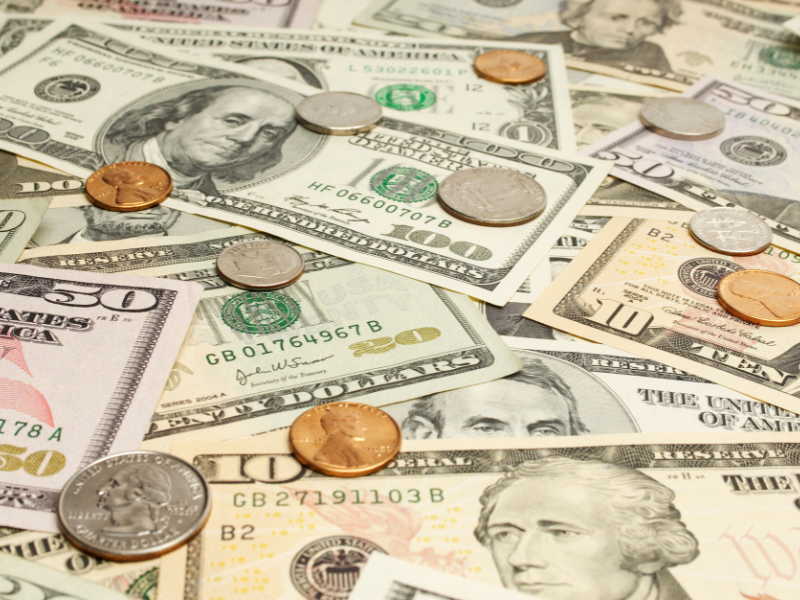 Various dollar bills and coins symbolizing beauty treatment expenses and costs