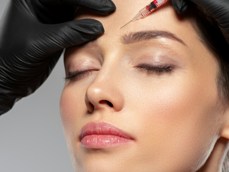 Close-up of woman receiving forehead injection for wrinkle treatment