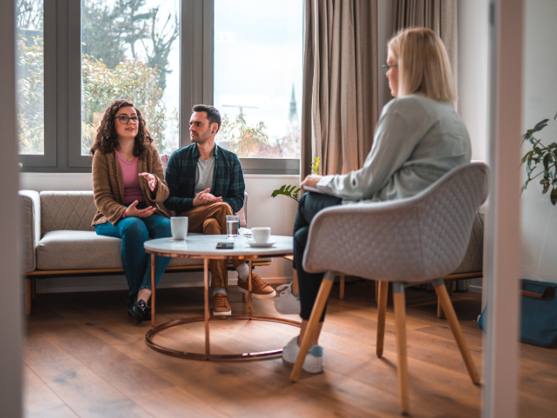 A couple discussing issues with a therapist in a session