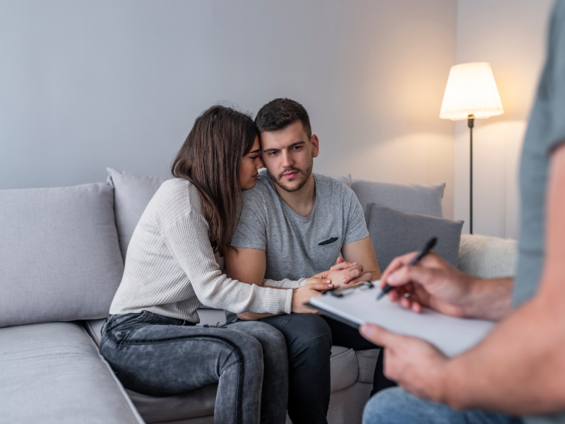A couple holding hands during a counseling session for support