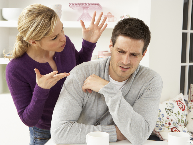 Woman argues with man at kitchen table over coffee