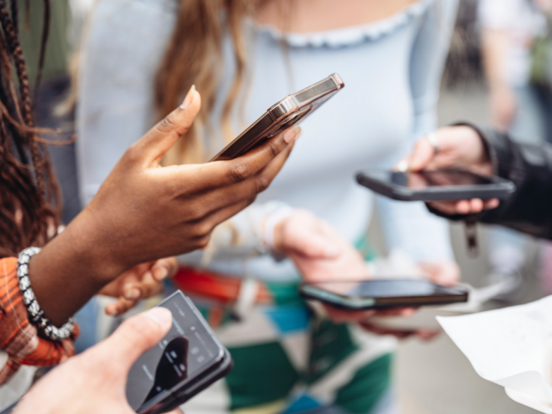 Group of people holding smartphones, engaged in online conversations