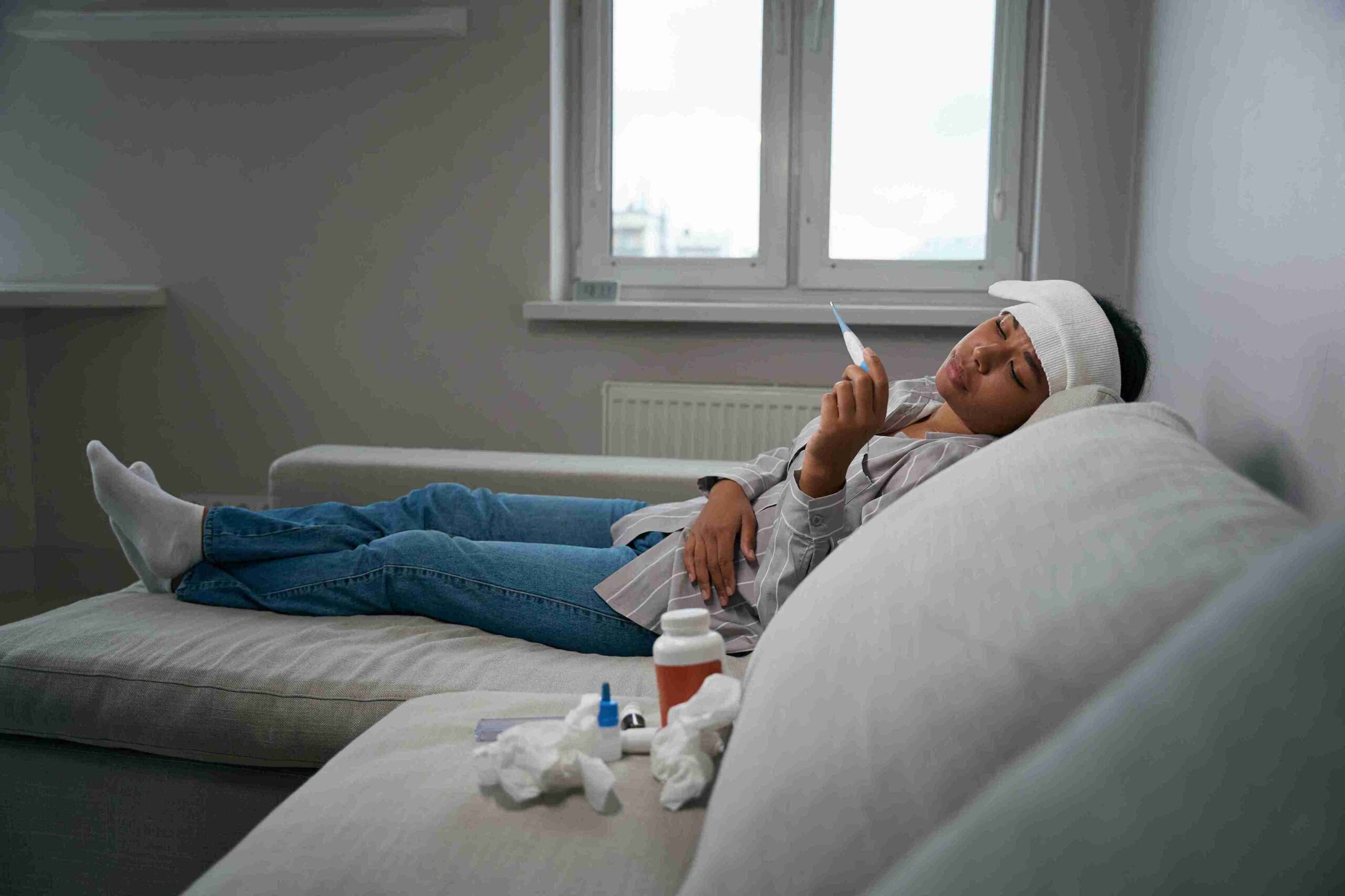 african-american-female-lies-on-the-couch-with-hig-2025-03-08-23-34-54-utc_11zon - Allure Wellness sick woman lying on the couch
