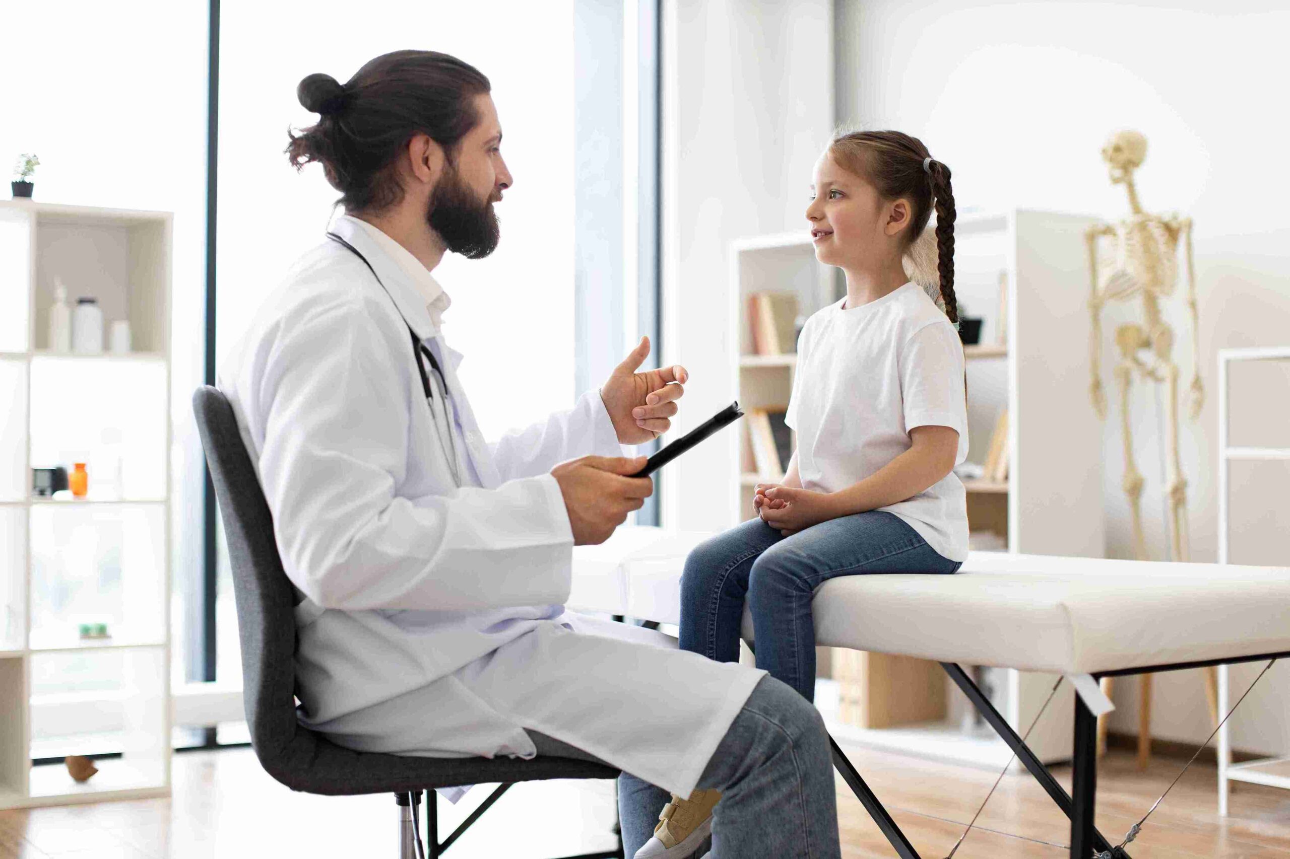 caring-doctor-talks-to-young-girl-during-medical-e-2024-12-13-16-25-36-utc_11zon - Allure Wellness doctor speaking with a child patient