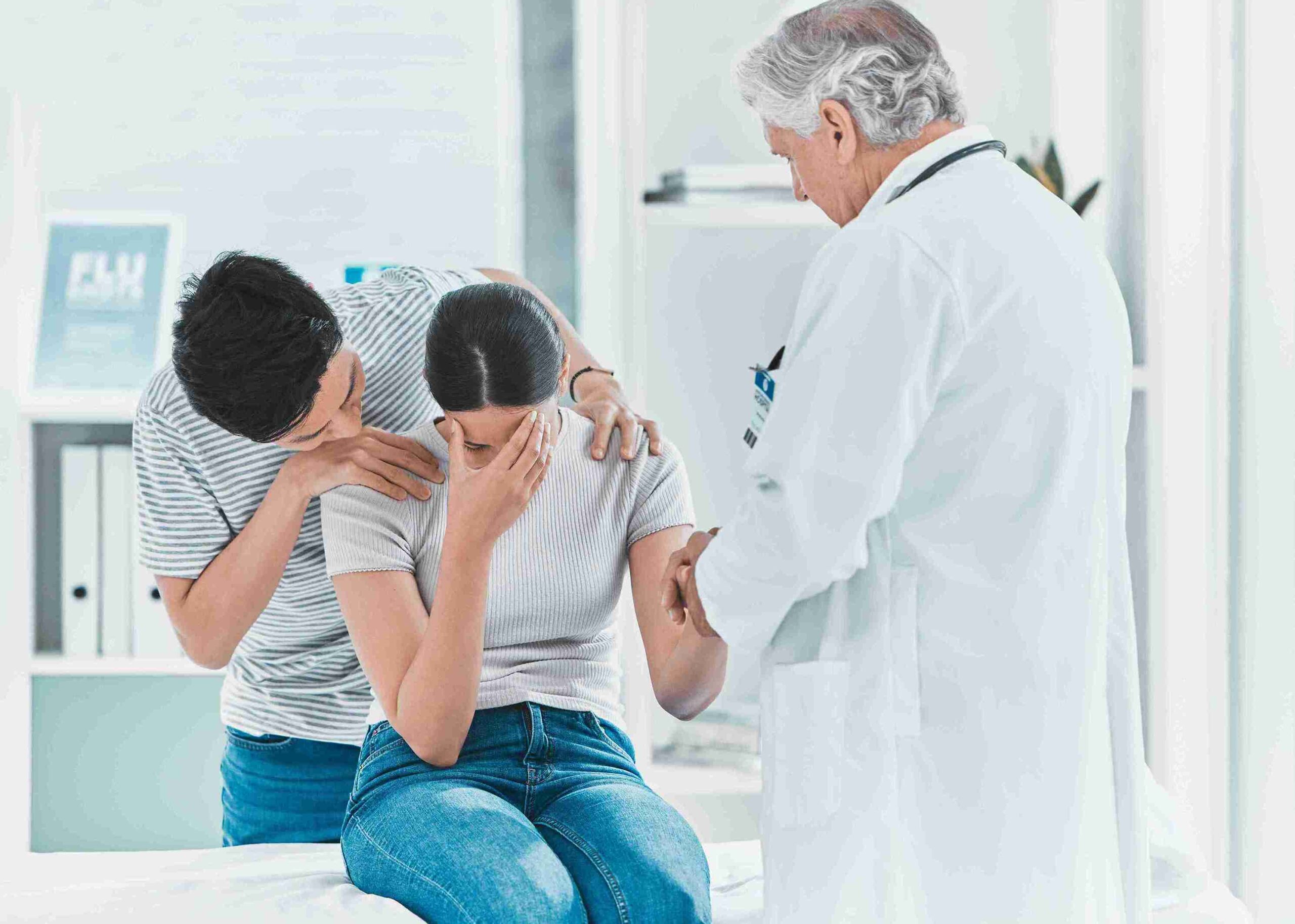 doctor and significant other comforting a female patient
