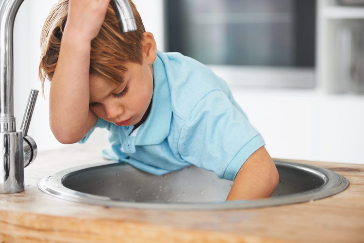 young boy looking at the sink