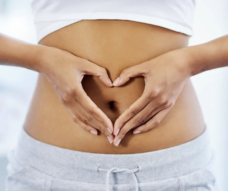 A person forming a heart shape with their hands over their abdomen, symbolizing digestive wellness