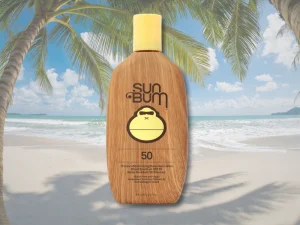 Sun Bum SPF 50 sunscreen bottle on a tropical beach