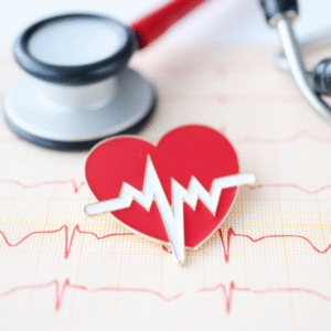 a heart pin beside a stethoscope on top of a electrocardiogram results.