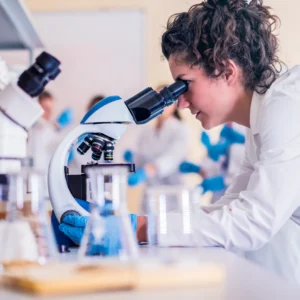 a woman scientist studying nmn using a microscope