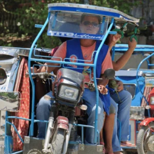 Man riding blue tricycle